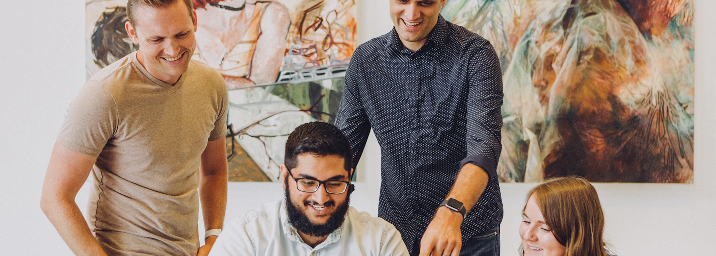 Young colleagues working together around a laptop in an office
